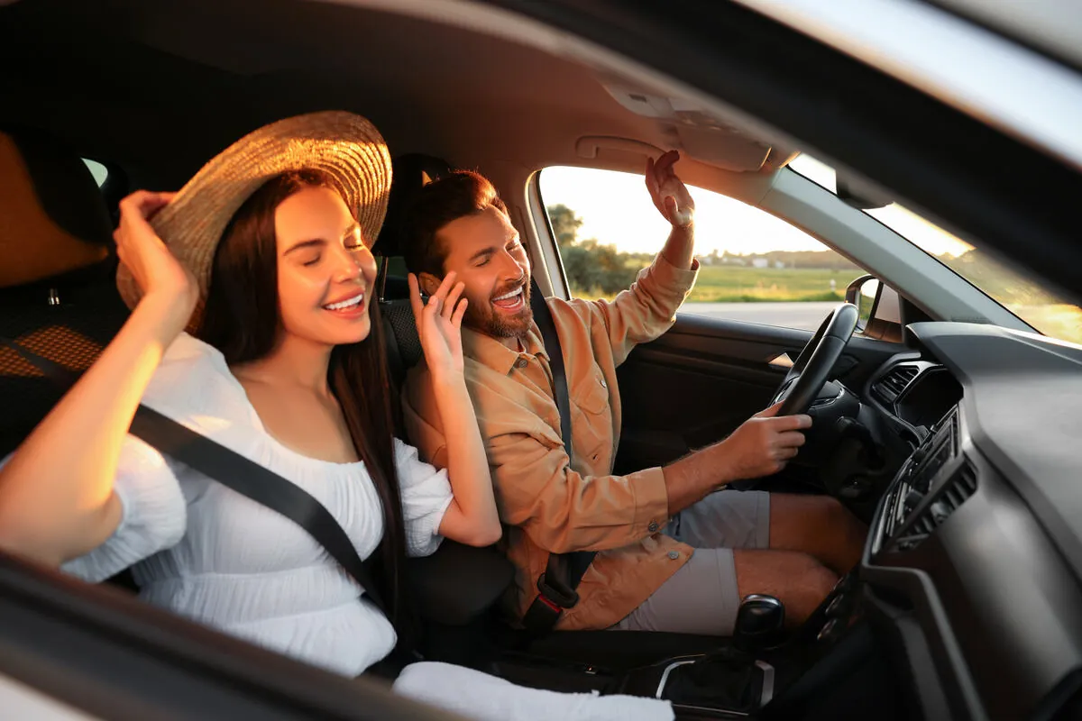Two friends singing along to the radio on a drive